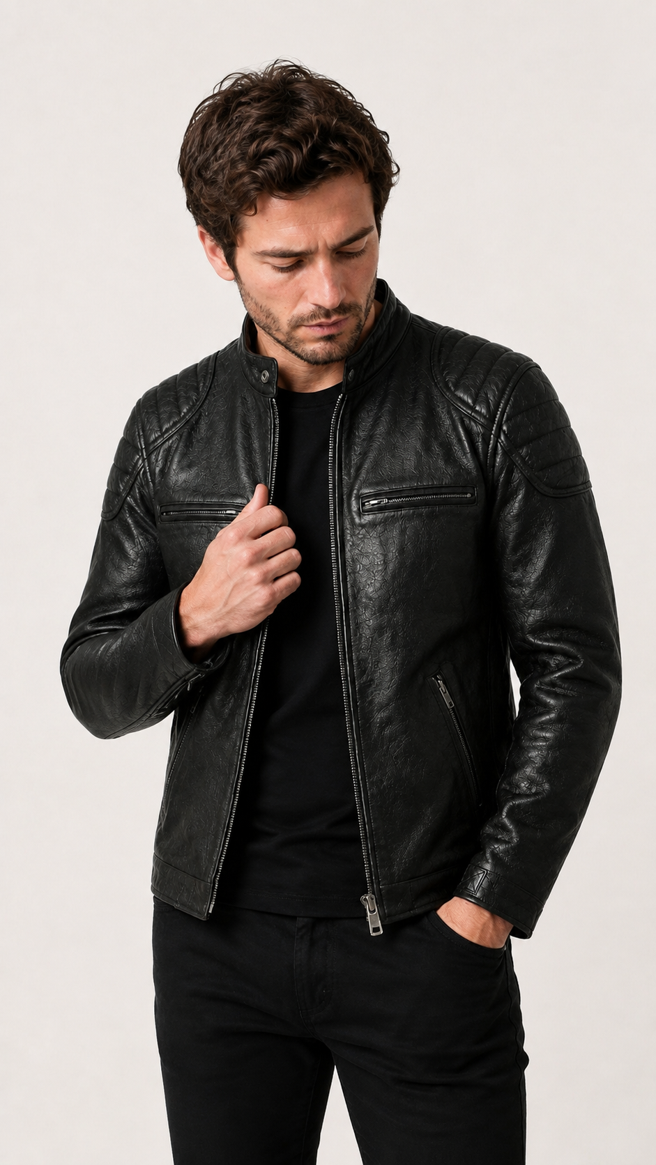 Man wearing the black biker jacket open over a dark tee — British model