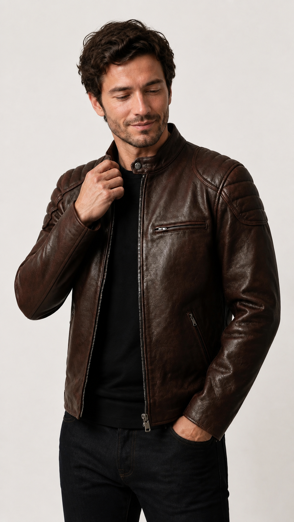 Man adjusting the collar of the vintage brown leather biker jacket — British model